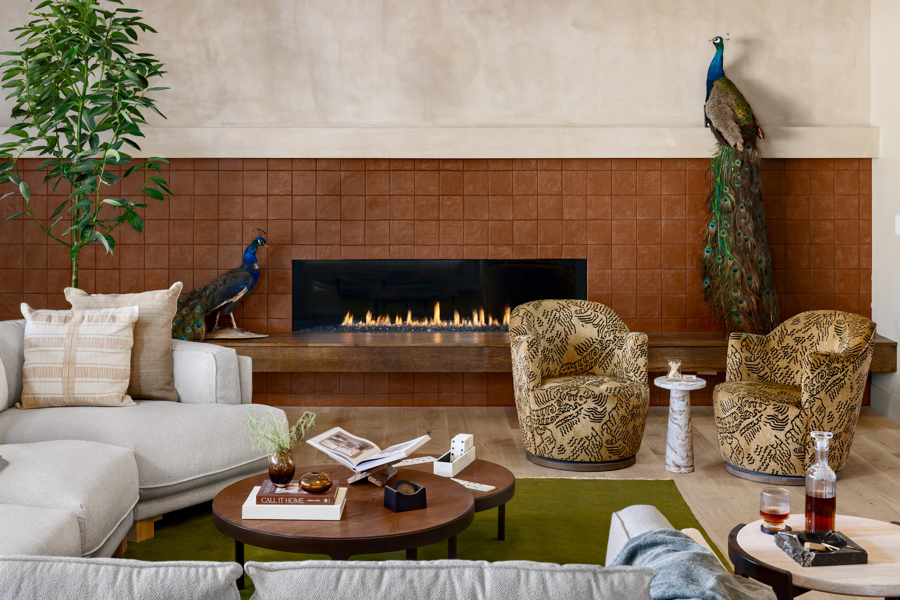 Great room with patterned upholstered accent chairs and a terracotta tile fireplace