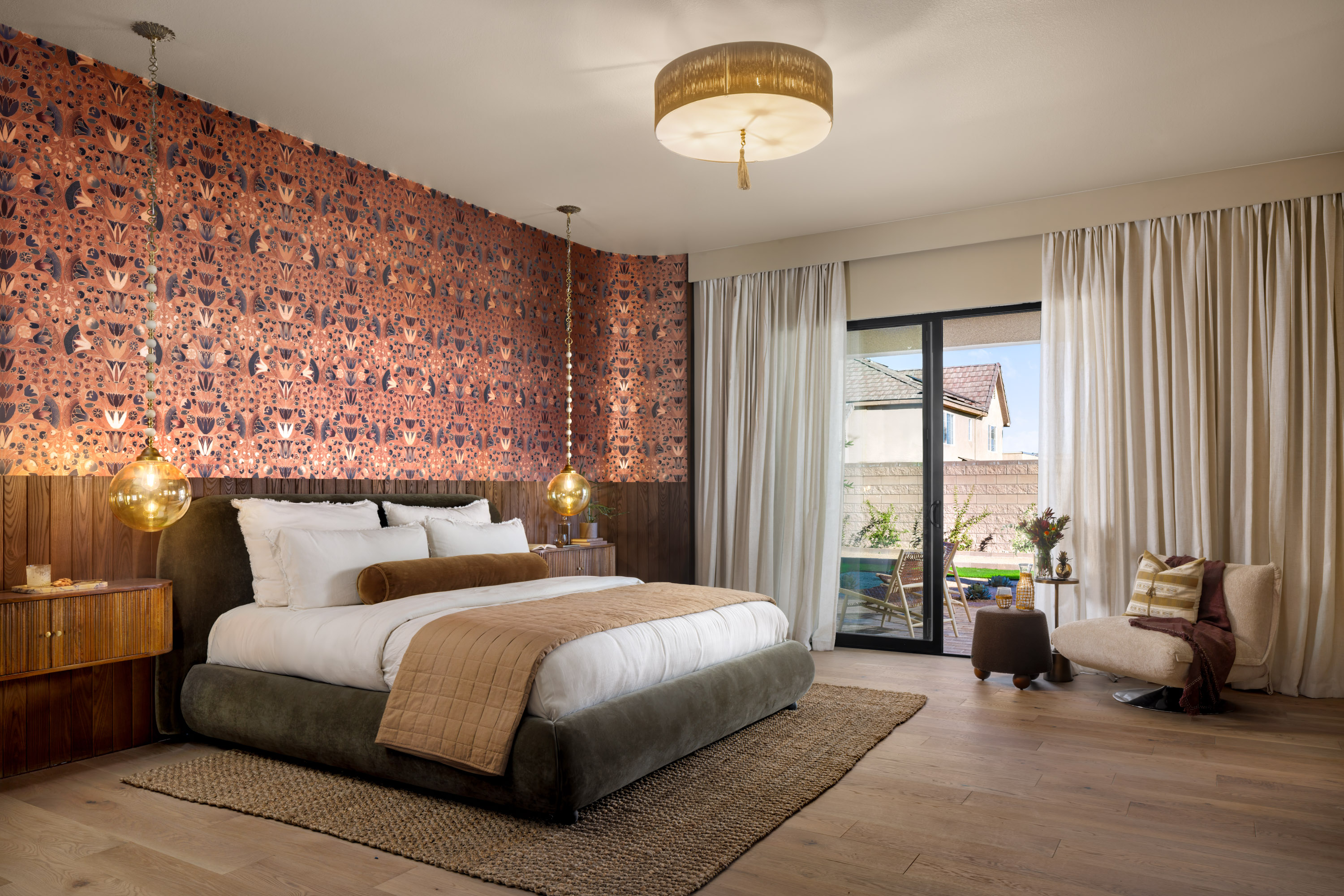 Primary bedroom with an olive velvet upholstered bed and warm textiles